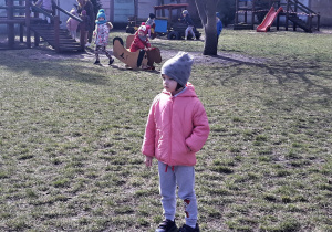 Dziewczynka spaceruje w ogrodzie przedszkolnym